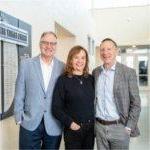 three people standing near hall of fame wall in the Fieldhouse